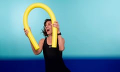 Zoe Williams holding a swim noodle, pretending to do aqua aerobics