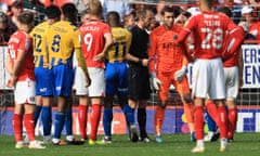 Players react as Charlton stewards remove a fan alleged to have racially abused Shrewsbury goalkeeper Marko Marosi.
