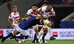 Japan's Michael Leitch tries to run through a tackle by a Samoan player.