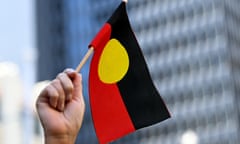 A protesters waves the Australian Aboriginal flag during an Invasion Day rally in Sydney