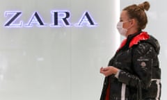 A woman in a medical mask walks past a Zara store in Moscow.