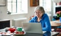 Older woman wearing glasses using laptop at home