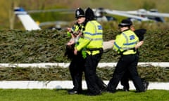 Police remove an animal rights protester before the start of the 2023 Grand National at Aintree.