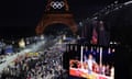 Spectators watch French singer Philippe Katerine performing on a giant screeen during the opening ceremony of the Paris 2024 Olympic Games in Paris.