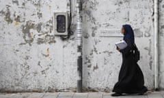 A woman walks on a footpath of the Maldives capital Male