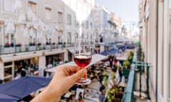 Saúde! Enjoy Portugal's ever-broadening wine styles, as this man's hand is, above a market in Lisbon.