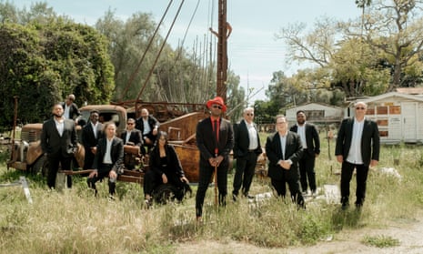 The members of Orquesta Akokán standing by the side of a road amid trees