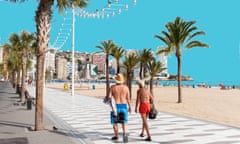 Man and woman in beach attire strolling along the promenade in Benidorm, Spain