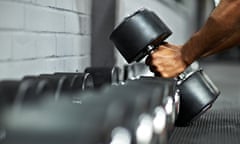 Man picking up dumbbells in a gym
