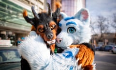 Two people hugging in animal costumes.