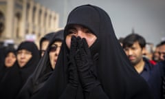 An Iranian woman weeps as she takes to the streets to mourn the death of General Qassem Suleimani