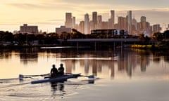 Rowers make their way along the Maribyrnong River towards the Melbourne skyline in the early morning.