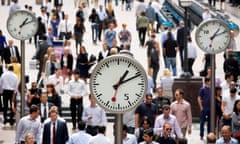 City Workers In The Canary Wharf Business, Financial And Shopping District<br>Office workers pass clocks in the Canary Wharf business and shopping district in London, U.K., on Friday, July 12, 2013. Recent data suggest Britain's economic recovery is gaining momentum after a return to growth in the first quarter. Photographer: Simon Dawson/Bloomberg via Getty Images EMEA; EUROPE|BANK; BANKS; BANKER; BANKING; M|BUSINESS; FINANCE; FINANCIAL|CONSUMER; GOODS|SKYSCRAPER;