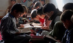 Two rows of young boys sit on the floor reading