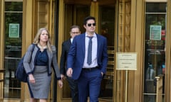 Man wearing blue suit and sunglasses walks out of door