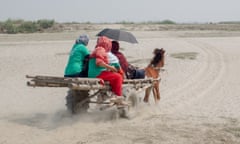 Health workers travelling by wooden cart pulled by a horse across sands in Kurigram, northern Bangladesh.