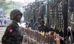 Soldiers stand next to military vehicles in Yangon, Myanmar.