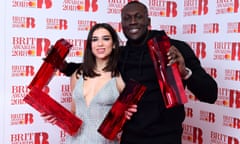 Dua Lipa and Stormzy with their respective braces of awards backstage at the Brits.