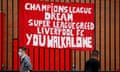 People walk past anti-Super League banners outside Anfield.