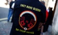 A person wearing a T-shirt reading ‘They have blood on their hands’ stands outside Westminster, London, on 20 May 2024