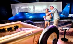A father and daughter look at land-record-speed breaking cars at the National Motor Museum, Beaulieu, Hampshire, UK>