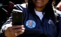 FILE PHOTO: Trial over Ahmaud Arbery's killing in Brunswick, Georgia<br>FILE PHOTO: A woman wears a badge depicting Ahmaud Arbery as she watches on her phone the trial of William "Roddie" Bryan, Travis McMichael and Gregory McMichael, charged with the February 2020 death of 25-year-old Ahmaud Arbery, in Brunswick, Georgia, U.S., November 23, 2021. REUTERS/Marco Bello TPX IMAGES OF THE DAY/File Photo