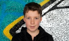 Alex Baugh, 12, in a black polo shirt with a shiny silver and blue background