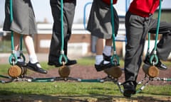 Children in school uniform on climbing equipment.