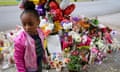 A young girl looks at a memorial in the wake of a weekend shooting at a Tops supermarket in Buffalo, New York.