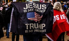 a person holds a flag that reads "Jesus is my savior Trump is my president"