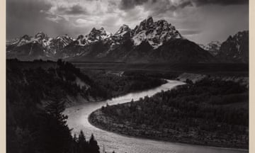 black and white photo of a gleaming river winding in front of a snow-topped mountain