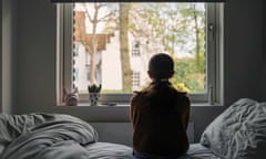 Powerful portrait of a young girl looking out of her bedroom window<br>A young girl looks out of her bedroom window. The view through the window is blurry but shows a residential area.