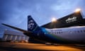 An Alaska Airlines plane is parked at the hangar
