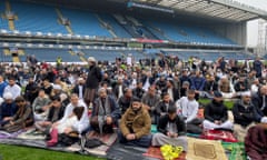 People gather for prayers on the pitch at Ewood Park