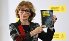 A middle-aged woman holds up a report that says: 'The state of the world's human rights' with the Amnesty candle and barbed-wire logo behind her