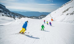 people in bright colours skiing down snowy piste