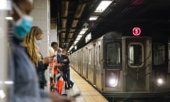 People stand on a platform of a subway station in New York. 