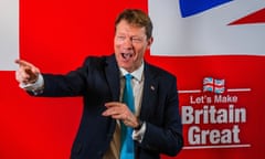 Richard Tice, the leader of Reform UK, points and laughs on stage during a conference in London on 3 January. Behind him, a slogan reads: 'Let's make Britain great'