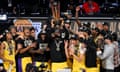 Los Angeles Lakers forward LeBron James (23) hoists the NBA Cup and celebrates with teammates after Saturday’s win over the Pacers.