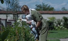 The Zone of Interest, sandra huller as hedy hoss with her baby, tending to the flowers in her garden next door to auschwitz