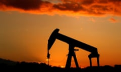 A oil pump is seen at sunset