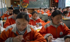 Students wear orange jumpers in a classroom