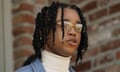 A man in a white turtleneck and glasses speaks during a news conference.