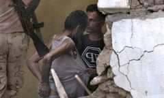 A suspected Isis fighter is led away after surrendering to Iraqi army soldiers on 18 July amid the ruins of the Old City.