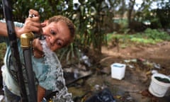 A child drinks from an open-air tap