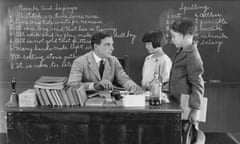 A school teacher telling off two pupils in a classroom