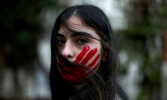 A Lebanese woman with her face painted with a red hand