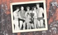 Black and white shot of the Von Erich family including the father, all in wrestling attire, with Kevin in the centre holding a wrestling trophy.