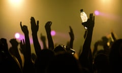 Crowd of clubbers dancing at a rave nightclub.