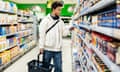 A young man reading the product description while shopping for groceries in his local supermarket.